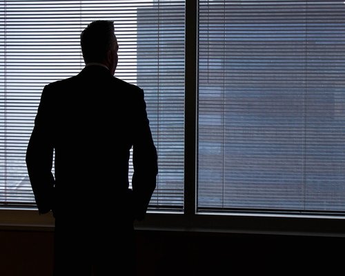 Person taking a break from computer looking out the window in a modern office